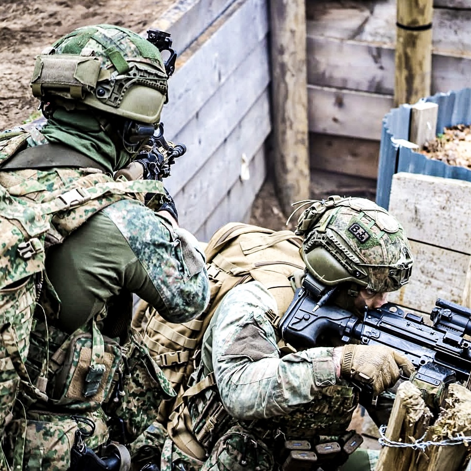 Two armed soliders in trenches, aiming their weapons.