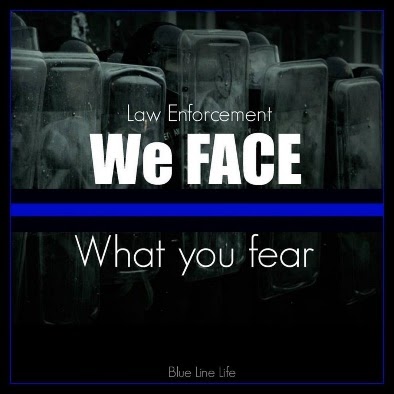 Law enforcement stand lined up behind shields with the headline "We face what you fear".