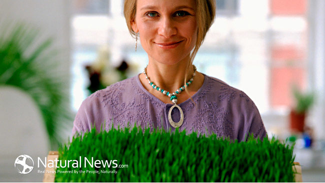A woman holds a tray of wheatgrass in a nice house.